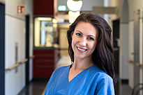 junge Frau in blauem Kasack auf Krankenhausflur, herzchirurgin Rostock